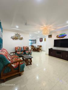 een woonkamer met banken en een flatscreen-tv bij Visweswara grand in Vijayawāda