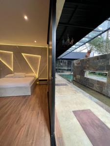 a bedroom with a bed and a stone wall at Hotel Suites Lounge Cañasgordas in Cali