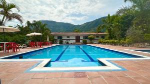 a swimming pool in front of a house at Finca Hotel Villaruth in Apulo