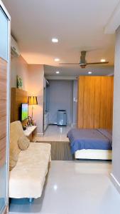 a bedroom with a bed and a couch at Cozy Stay at Shaftsbury Residences by SNS HOMES in Cyberjaya