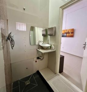 La salle de bains est pourvue d'un lavabo et d'un miroir. dans l'établissement Blue Sea Studio 1 minute away from Luanda Bay, à Luanda