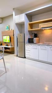 Il comprend une cuisine équipée d'un réfrigérateur et d'une table. dans l'établissement Cozy Stay at Shaftsbury Residences by SNS HOMES, à Cyberjaya