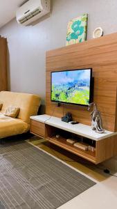 un soggiorno con TV a schermo piatto su un centro di intrattenimento di Cozy Stay at Shaftsbury Residences by SNS HOMES a Cyberjaya