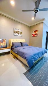 - une chambre avec un lit et un ventilateur de plafond dans l'établissement Cozy Stay at Shaftsbury Residences by SNS HOMES, à Cyberjaya