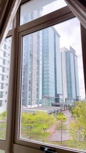una ventana con vistas a una ciudad con edificios altos en Cozy Stay at Shaftsbury Residences by SNS HOMES, en Cyberjaya