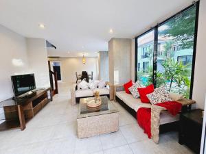 KRAAM VILLAS في تالانغ: غرفة معيشة مع أريكة وتلفزيون