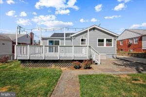 a white house with a white deck in a yard at LOVELY 2 BEDROOMS APPARTEMENT, LAUNDRY/PARKING/TV in Silver Spring