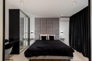 sypialnia z czarnym łóżkiem i dużym lustrem w obiekcie Diamonds Apartment w Krakowie