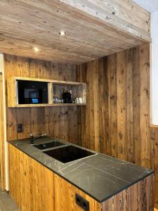 a kitchen with wooden walls and a counter top at Stegerhof in Santa Maddalena in Casies