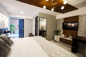 a bedroom with a large bed and a flat screen tv at Hotel Corregidor by Cassana in Arequipa