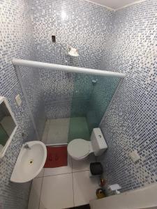 Baño pequeño con aseo y lavamanos en Hospedagem Suites Itaboraí, en Itaboraí