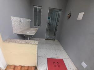 uma casa de banho com um lavatório e uma cabina de duche em vidro. em Hospedagem Suites Itaboraí em Itaboraí