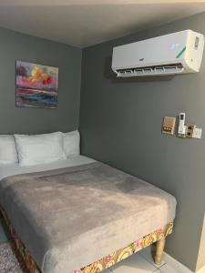 a bedroom with a bed with a air conditioner on the wall at Malibu Ocean View Studio in Montego Bay