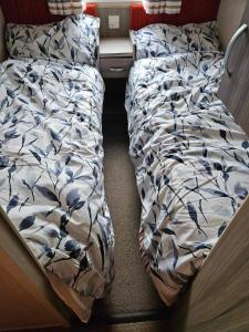 uma cama não feita num pequeno quarto com uma saia-cama em Swift Moselle em Lincolnshire