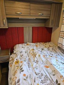 Lincolnshire的住宿－Swift Moselle，卧室内的一张带花卉棉被的床
