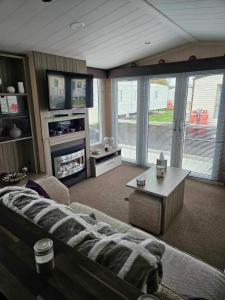 een woonkamer met een bank en een tv bij Swift Moselle in Lincolnshire