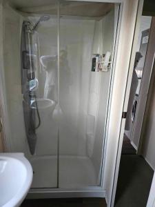 a shower stall in a bathroom next to a sink at Swift Moselle in Lincolnshire