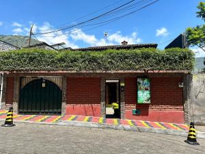 um edifício de tijolos com uma porta verde e hera em La Casa del Molino Blanco B&B em Baños