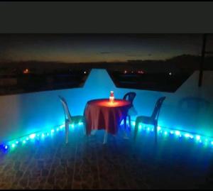 a table with a candle on it with two chairs at Titanic House by ahmed in Mirleft