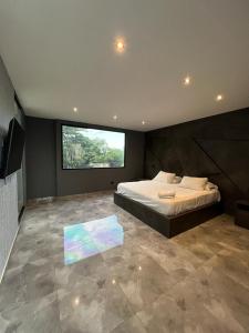 a bedroom with a large bed and a large window at Hotel Suites Lounge Cañasgordas in Cali