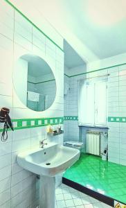 La salle de bains est pourvue d'un lavabo blanc et d'un sol vert. dans l'établissement Utopia Bed & Breakfast, à Marigliano