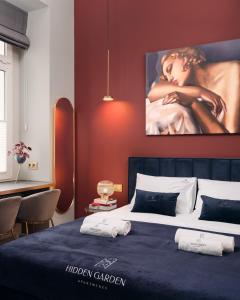a bedroom with a bed with a large painting on the wall at Hidden Garden Apartments in Łódź