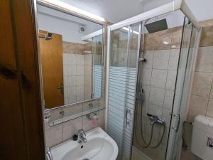 a bathroom with a shower and a sink and a toilet at Pagaseon Rooms and Apartments in Kala Nera