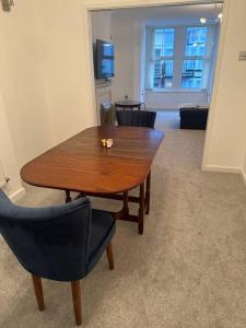 een houten tafel en stoelen in een kamer bij Cwtch By The Sea in Porthcawl