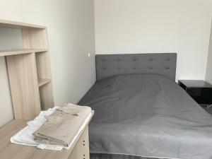 a bedroom with a bed and a table with towels on it at Vironia Apart in Kohtla-Järve