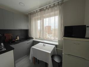 a small kitchen with a white table and a window at Vironia Apart in Kohtla-Järve