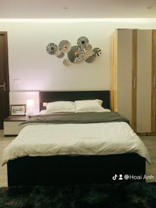 a bedroom with a large bed with two clocks on the wall at Green Line Long Bien - Serviced Apartment - Ngoc Thuy - Hanoi in Hanoi