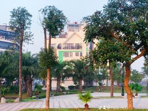 a park with trees and a building in the background at Green Line Long Bien - Serviced Apartment - Ngoc Thuy - Hanoi in Hanoi