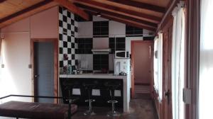a kitchen with black and white tiles on the wall at Cabañas Madera del Confin Angol in Angol