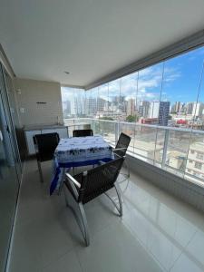 a table and chairs in a room with a view of a city at Ap à 10 min do carnaval in Salvador