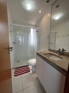 uma casa de banho com um chuveiro, um lavatório e um WC. em Ap à 10 min do carnaval em Salvador