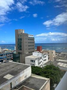 uma vista para uma cidade com edifícios e o oceano em Ap à 10 min do carnaval em Salvador