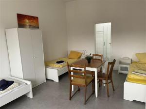 um quarto com uma mesa e cadeiras e um quarto com camas em moderne und schicke Unterkunft in Zeestow - jedes Schlafzimmer verfügt über ein eigenes Bad em Brieselang