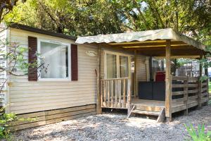 a small house with a porch and a window at Camping 3* Les Templiers in Roquebillière +14 photos