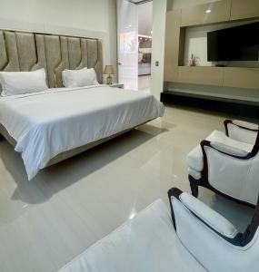 a bedroom with a large bed and a chair at Hotel Lotto Boutique in Cali