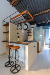 a kitchen with a counter and two stools in a room at Apartamento rústico industrial , enfrente de hotel prado in Barranquilla