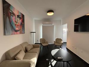 salon z kanapą i telewizorem z płaskim ekranem w obiekcie Venus Seaview 2B, Rooftop, PRIME Location, Paphos w Pafos