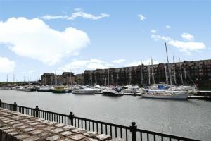 a group of boats docked in a marina with buildings at Entire cosy home in Liverpool Marina in Liverpool