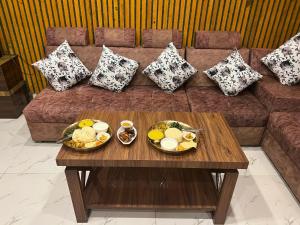 une table basse avec des assiettes de nourriture sur un canapé dans l'établissement Hotel Swargalok, à Pānigata