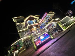un bâtiment avec des lumières sur le côté d'une rue dans l'établissement Hotel Swargalok, à Pānigata
