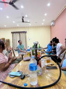 Un groupe de personnes assises autour d'une table dans l'établissement Hotel Swargalok, à Pānigata