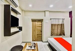 une chambre d'hôtel avec un lit et une télévision dans l'établissement HOTEL AIRPORT HEAVEN, à kolkata