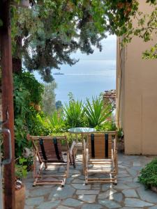 a patio with a table and two chairs and the ocean at Elma's Houses - Green House Yanna in Alonnisos