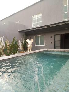 a teddy bear standing next to a house with a swimming pool at Hotel Suites Lounge La Viga in Cali