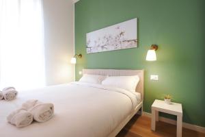 Un dormitorio con una cama blanca con toallas. en Primopiano - Russo, en Milán
