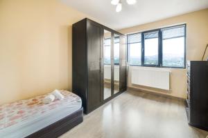 una camera da letto con un letto e una grande finestra di Vitosha View Apartment with Parking a Sofia